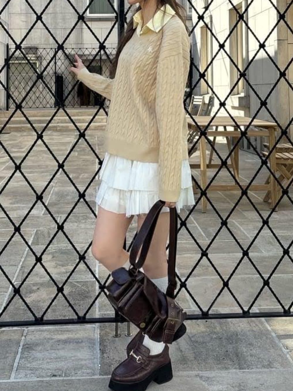 ベージュ系のニット/セーター、ホワイト系のスカート、ブラウン系のショルダーバッグを着用したレディースの冬コーディネートの1枚目の写真