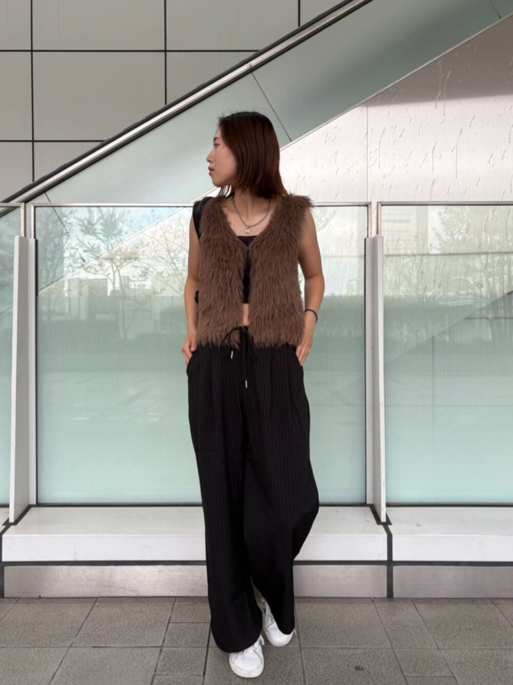 ブラック系のスラックス、ブラウン系のニット/セーターを着用したレディースの秋コーディネートの1枚目の写真