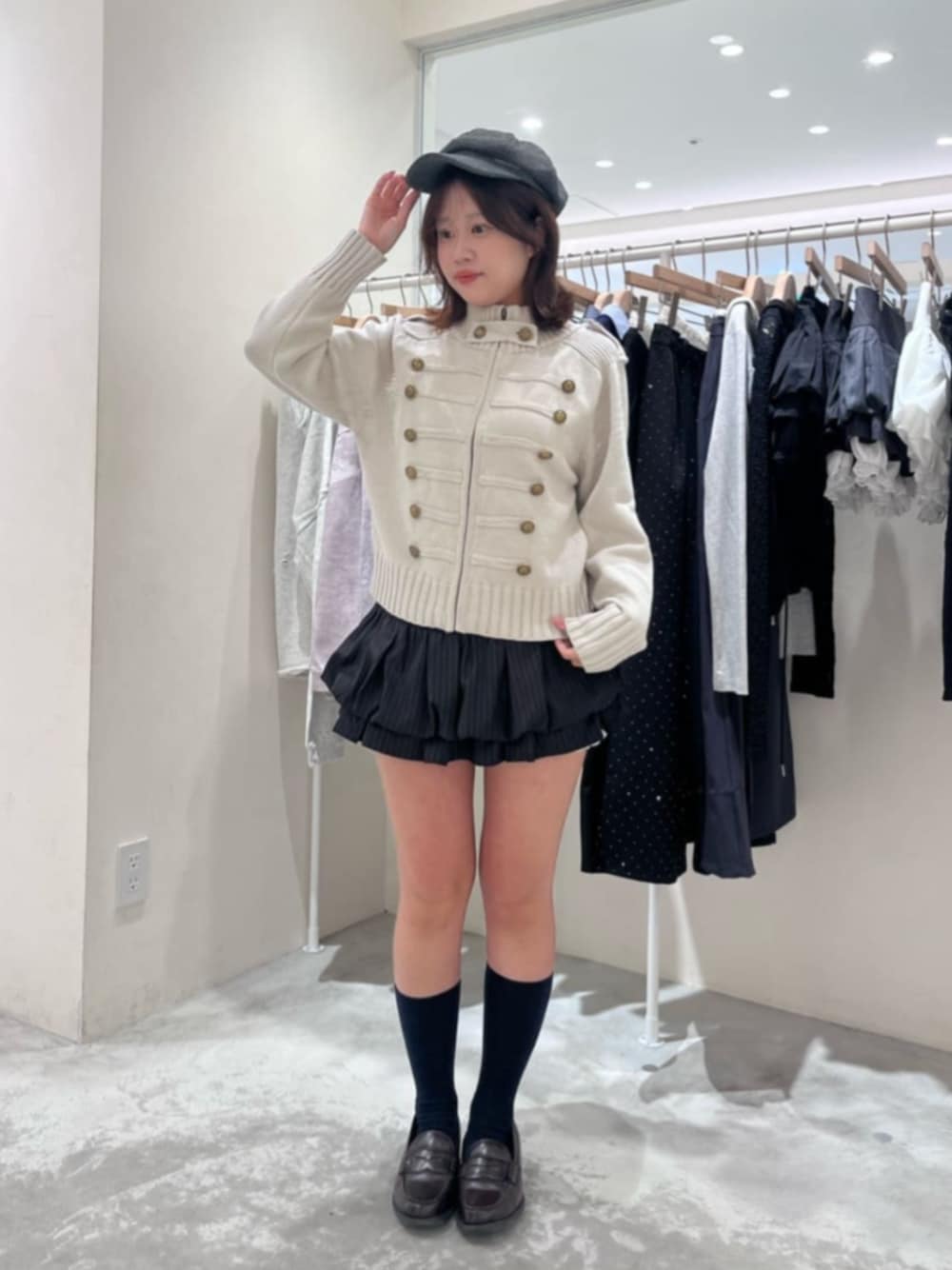 ブラック系のスカート、ホワイト系のニット/セーター、グレー系のキャスケットを着用したレディースの秋コーディネートの1枚目の写真