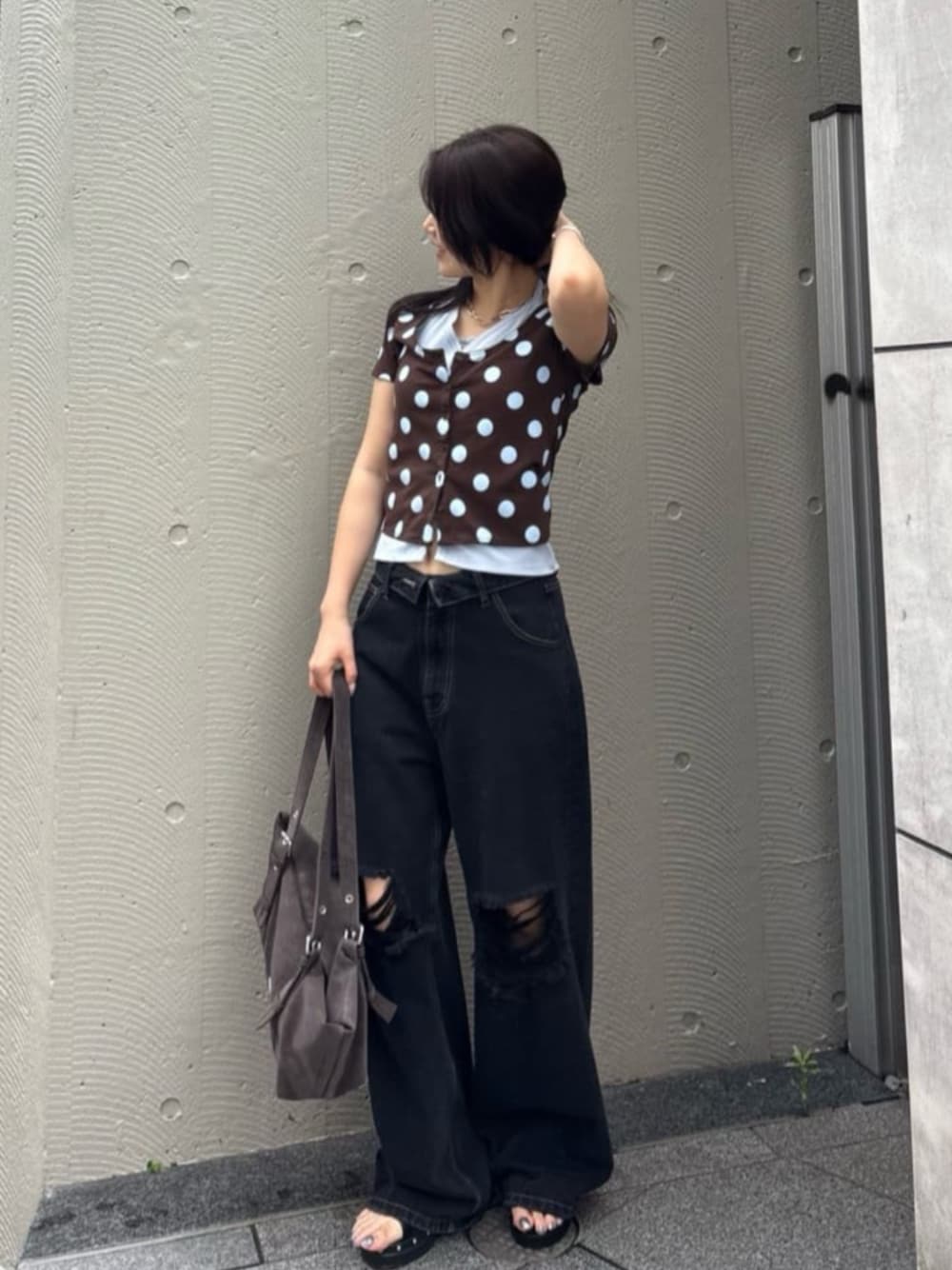 ブラック系のデニムパンツ、ブラウン系のトートバッグ、ブラウン系のTシャツ/カットソーを着用したレディースの夏コーディネートの1枚目の写真