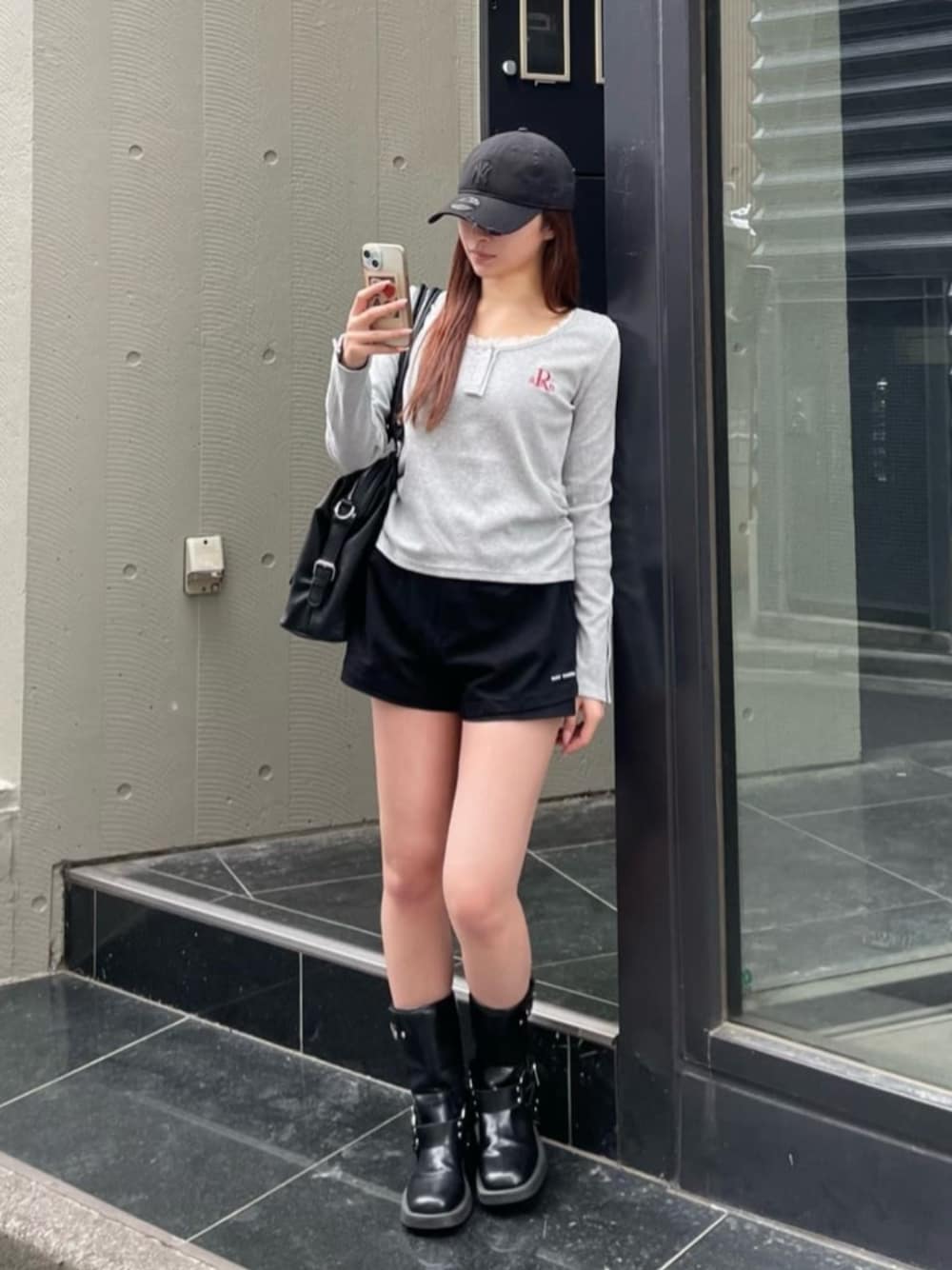 グレー系のTシャツ/カットソー、ブラック系のショルダーバッグを着用したレディースの春コーディネートの1枚目の写真