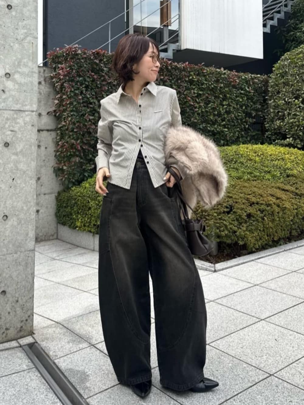 ブラック系のデニムパンツ、ホワイト系のシャツ/ブラウスを着用したレディースの春コーディネートの1枚目の写真