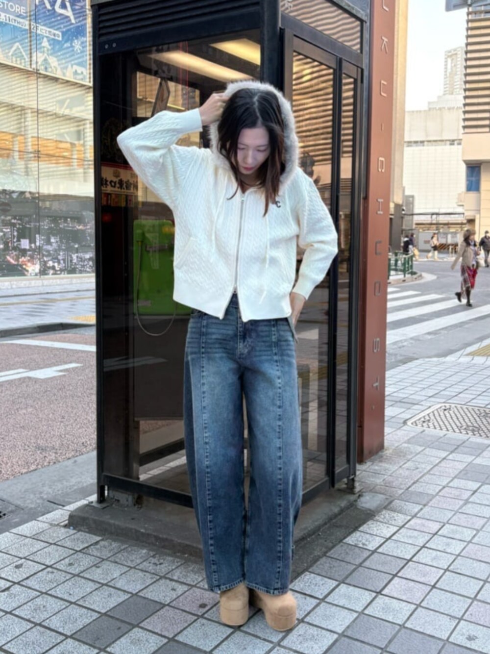 ベージュ系のパーカー、ベージュ系のスリッポン、ブルー系のデニムパンツを着用したレディースの冬コーディネートの1枚目の写真