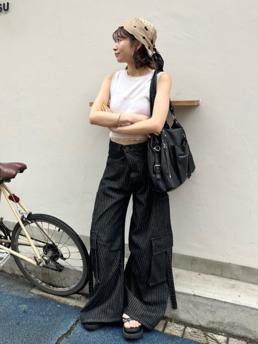 ブラック系のデニムパンツ、ブラック系のショルダーバッグを着用したレディースの夏コーディネートの1枚目の写真