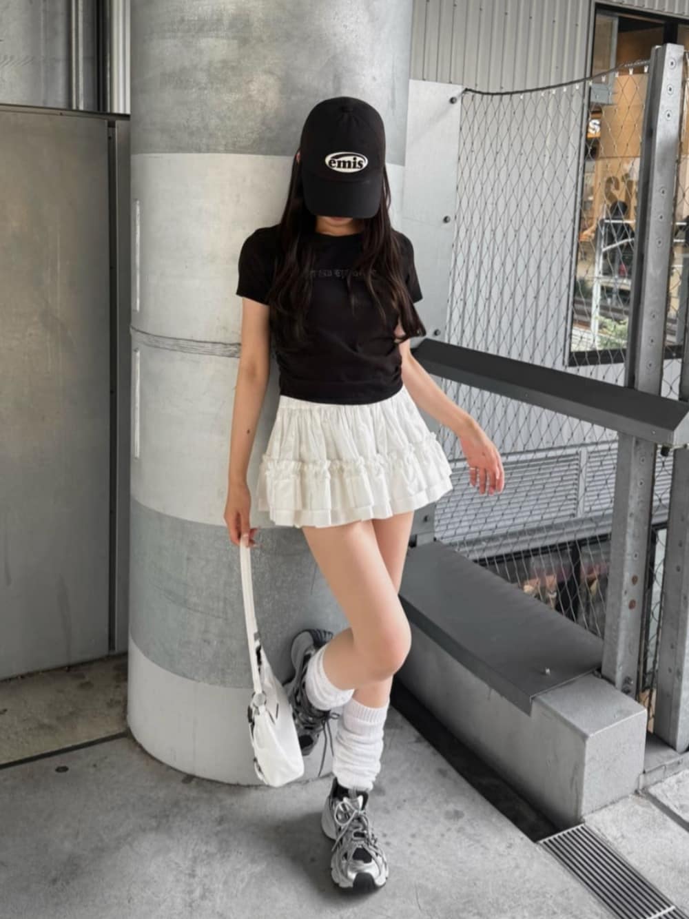 シルバー系のスニーカー、ブラック系のTシャツ/カットソー、ホワイト系のスカートを着用したレディースの春コーディネートの1枚目の写真
