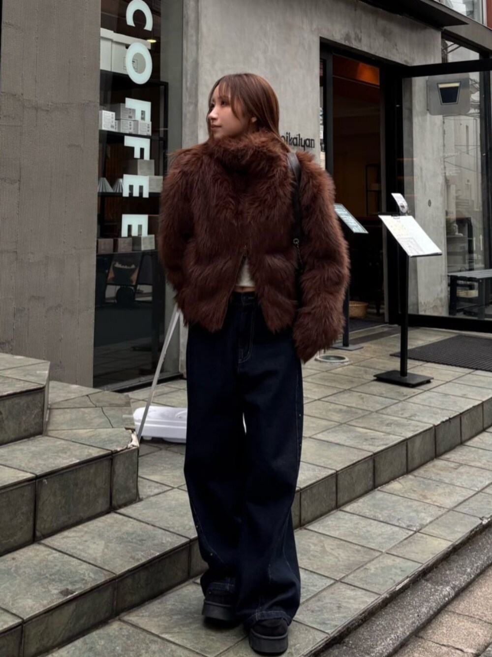 ブルー系のデニムパンツ、ブラック系のその他シューズ、ブラウン系のブルゾンを着用したレディースの秋コーディネートの1枚目の写真