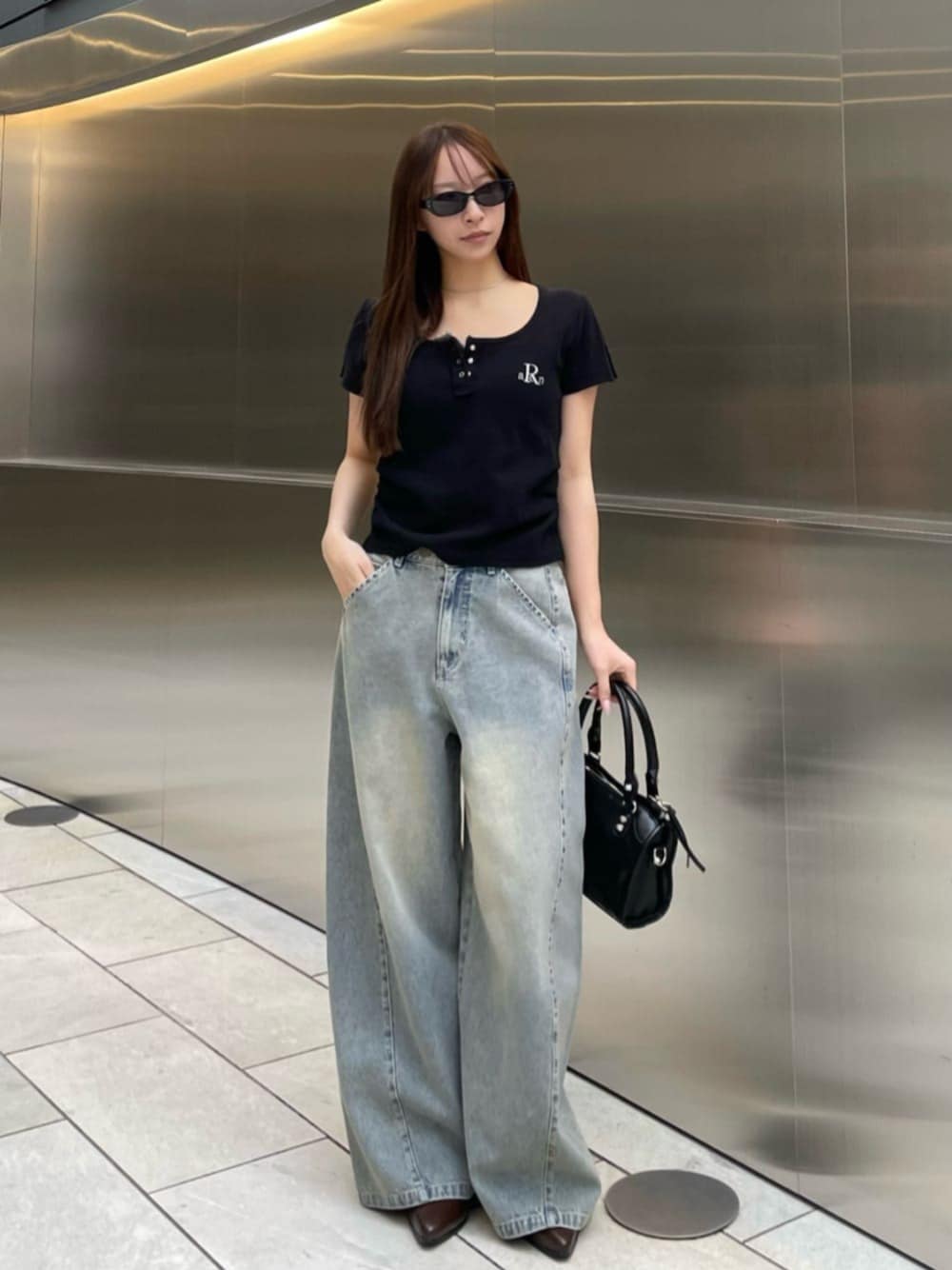 ブルー系のデニムパンツ、ブラック系のTシャツ/カットソーを着用したレディースの春コーディネートの1枚目の写真
