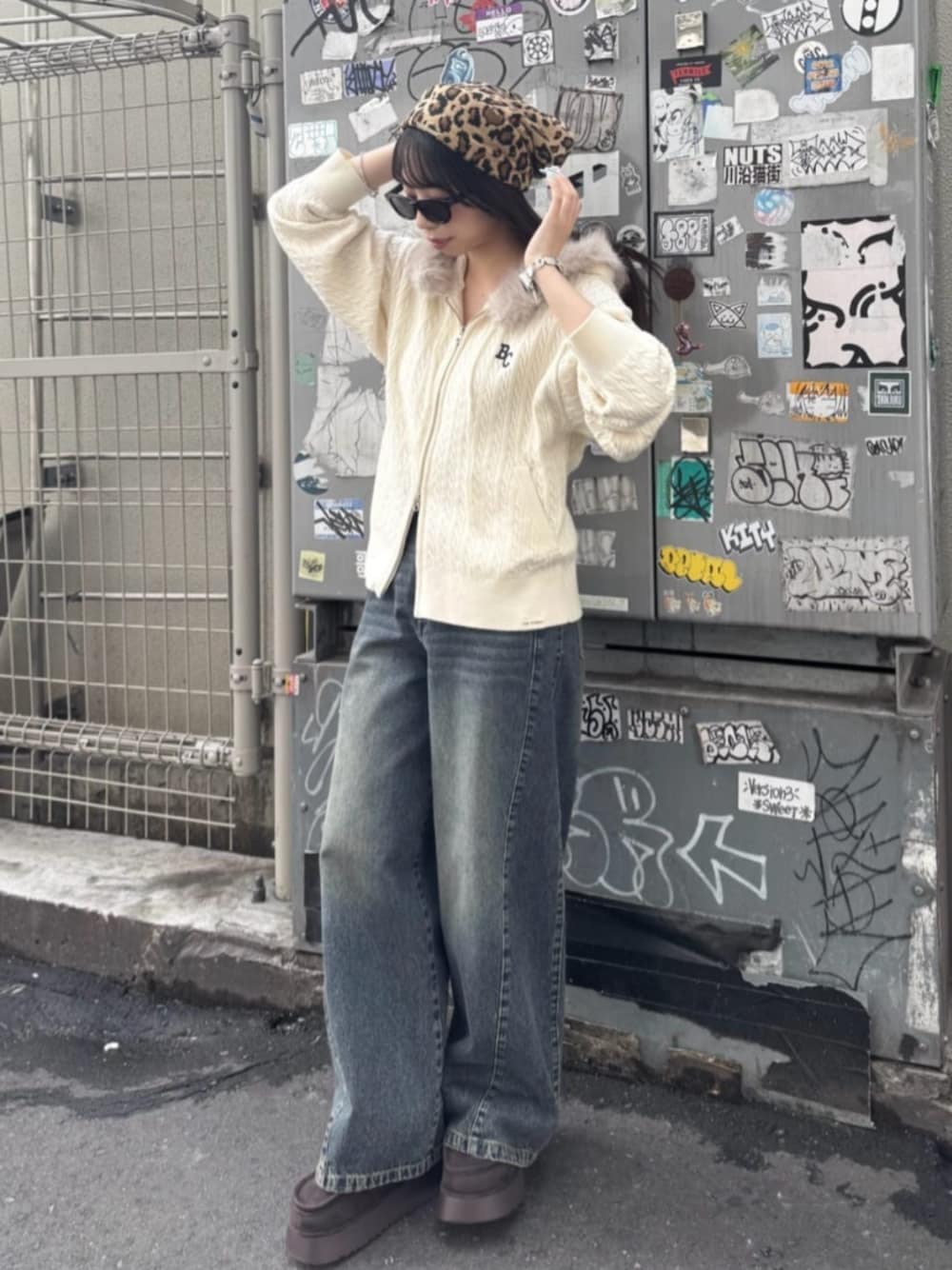 ベージュ系のパーカー、ブルー系のデニムパンツ、ブラウン系のブーツを着用したレディースの秋コーディネートの1枚目の写真