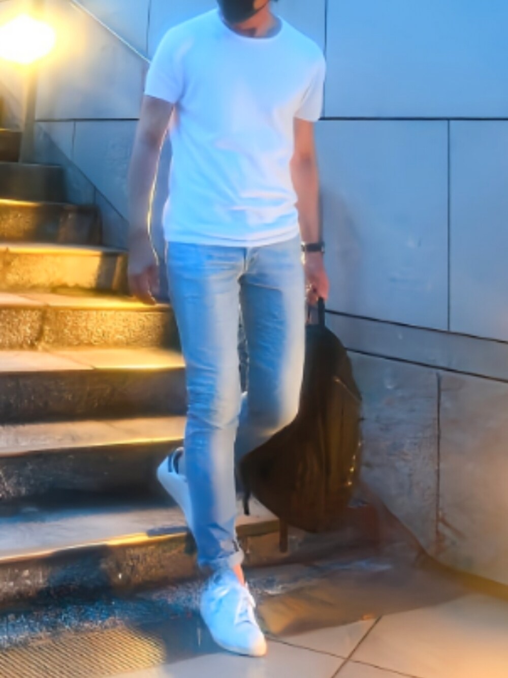 ホワイト系のスニーカー、ブルー系のデニムパンツ、ブラック系のバックパック/リュックを着用したメンズの夏コーディネートの1枚目の写真