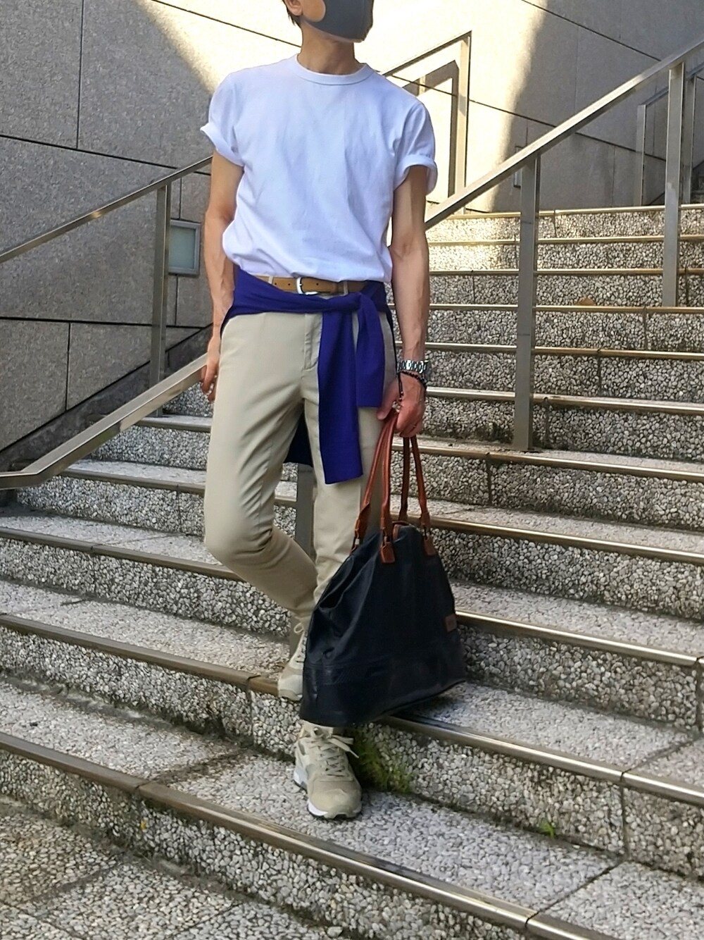 ベージュ系のスニーカー、ブラック系のトートバッグ、ベージュ系のチノパンツを着用したメンズの夏コーディネートの1枚目の写真