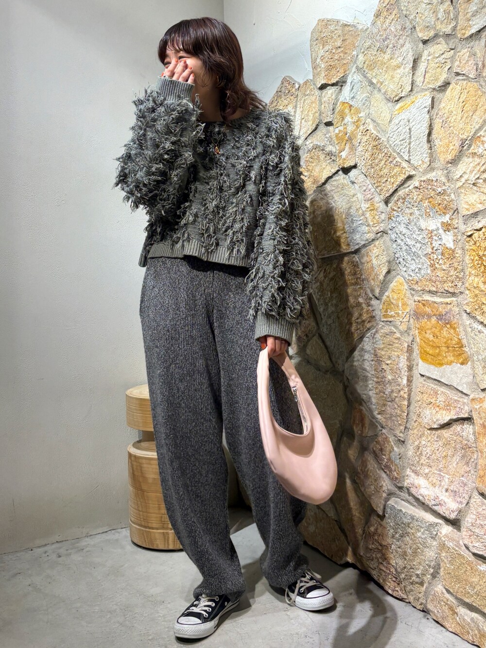 グレー系のニット/セーター、グレー系のその他パンツ、ピンク系のハンドバッグを着用したレディースの秋コーディネートの1枚目の写真