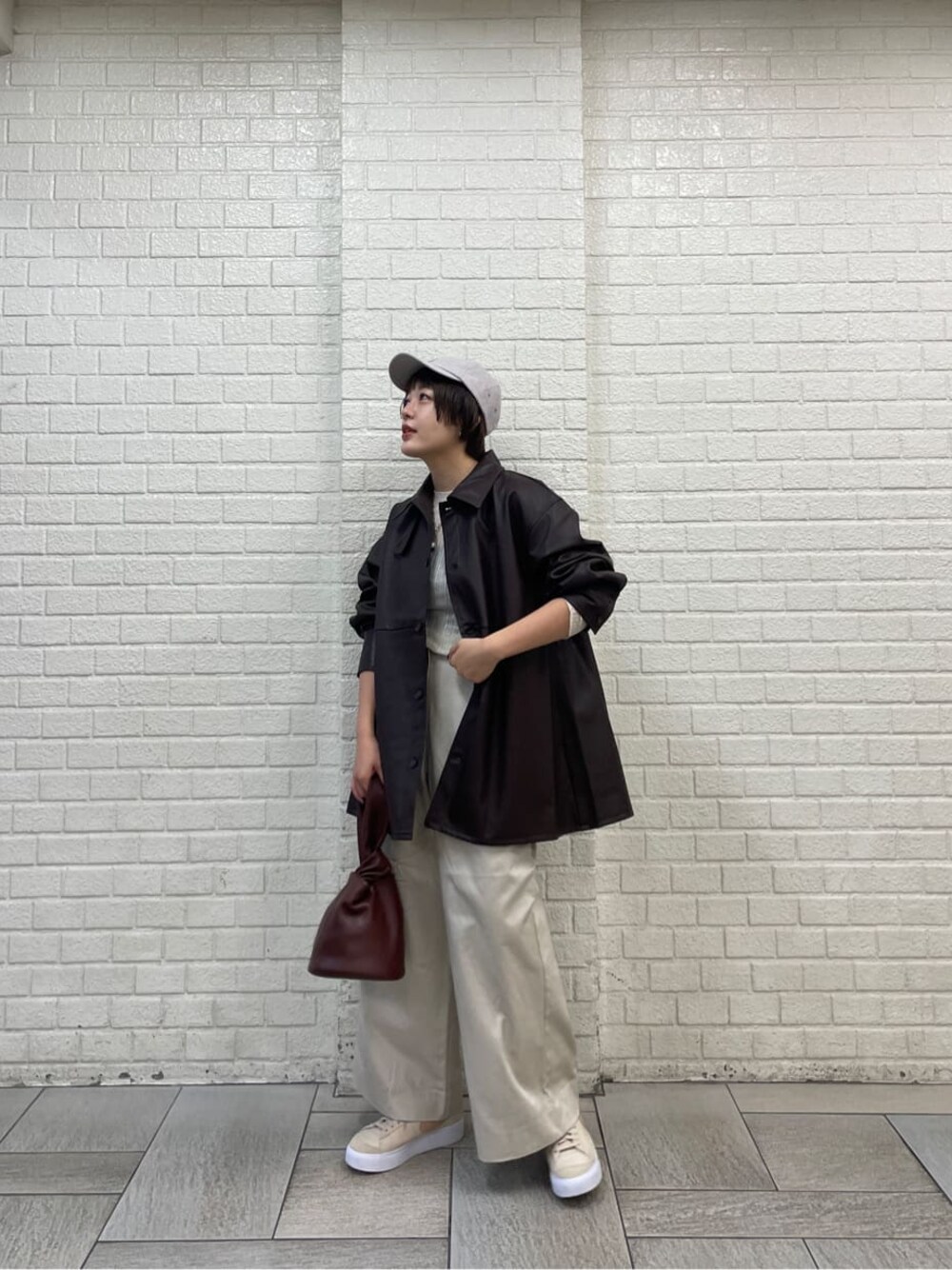 ホワイト系のニット/セーター、ブラウン系のハンドバッグ、ホワイト系のその他パンツを着用したレディースの秋コーディネートの1枚目の写真