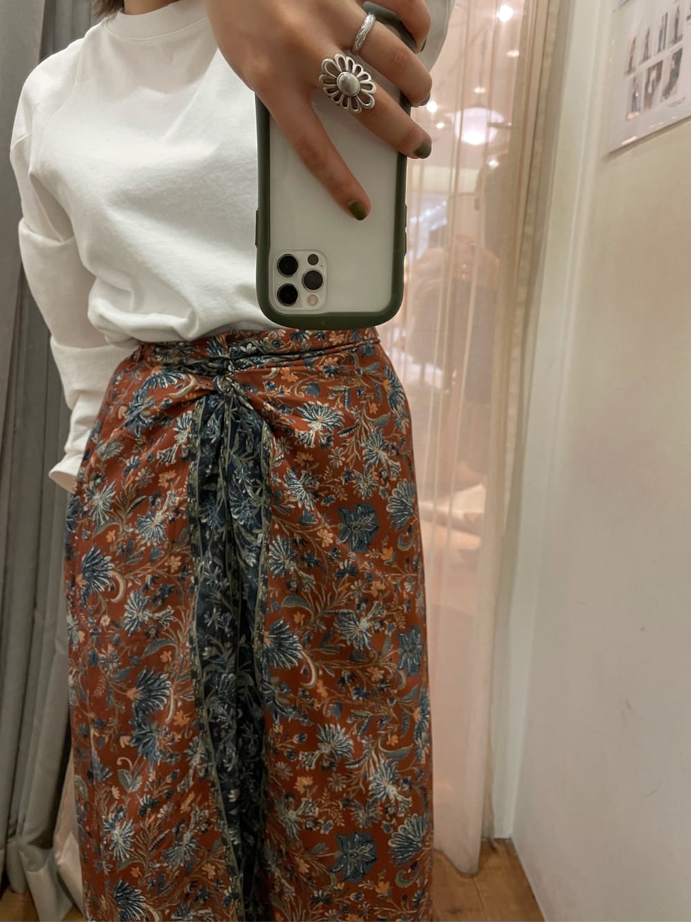 オレンジ系のスカート、ホワイト系のTシャツ/カットソーを着用したレディースの冬コーディネートの1枚目の写真