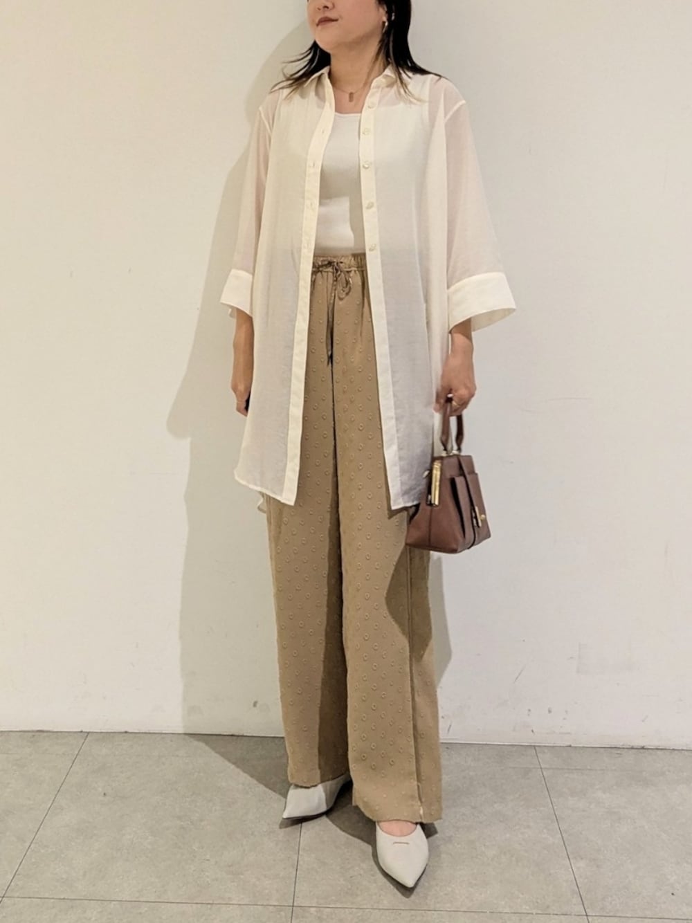 ホワイト系のシャツ/ブラウス、ベージュ系のその他パンツ、イエロー系のショルダーバッグを着用したレディースの秋コーディネートの1枚目の写真