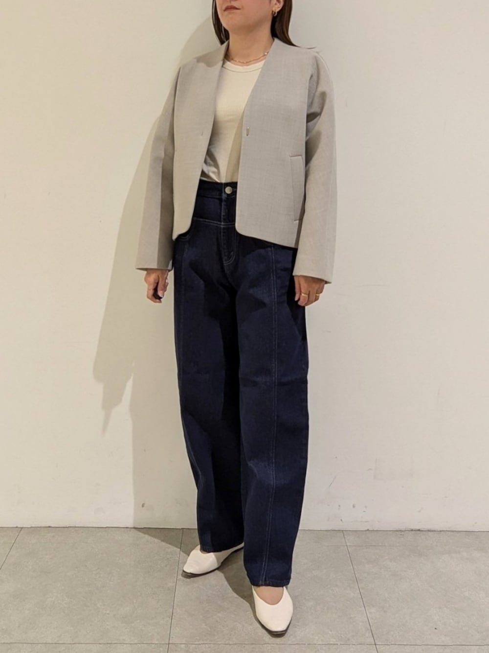 ベージュ系のノーカラージャケットを着用したレディースの秋コーディネートの1枚目の写真