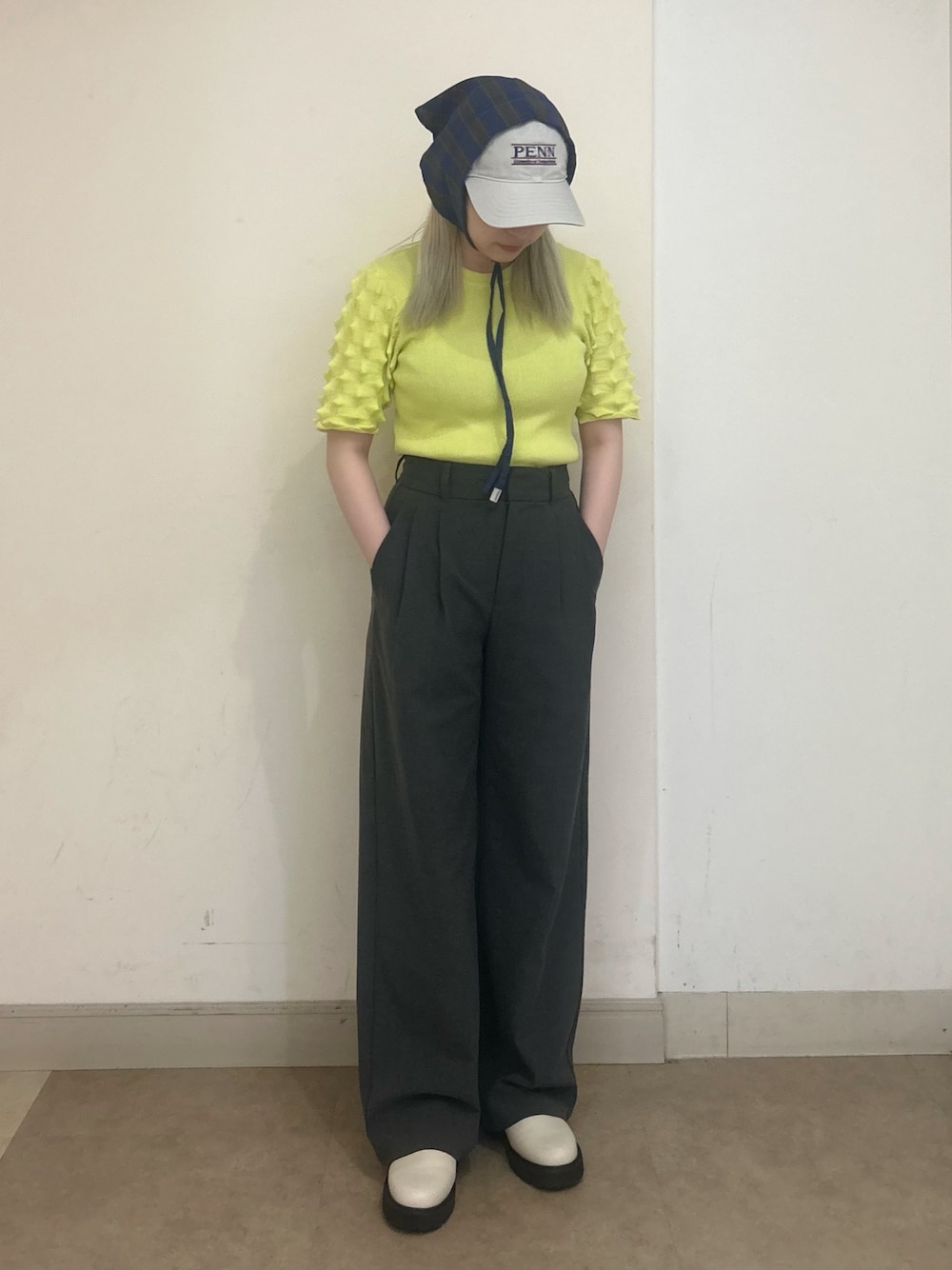 グリーン系のニット/セーター、グレー系のパンツ、ホワイト系のシューズを着用したレディースの夏コーディネートの1枚目の写真