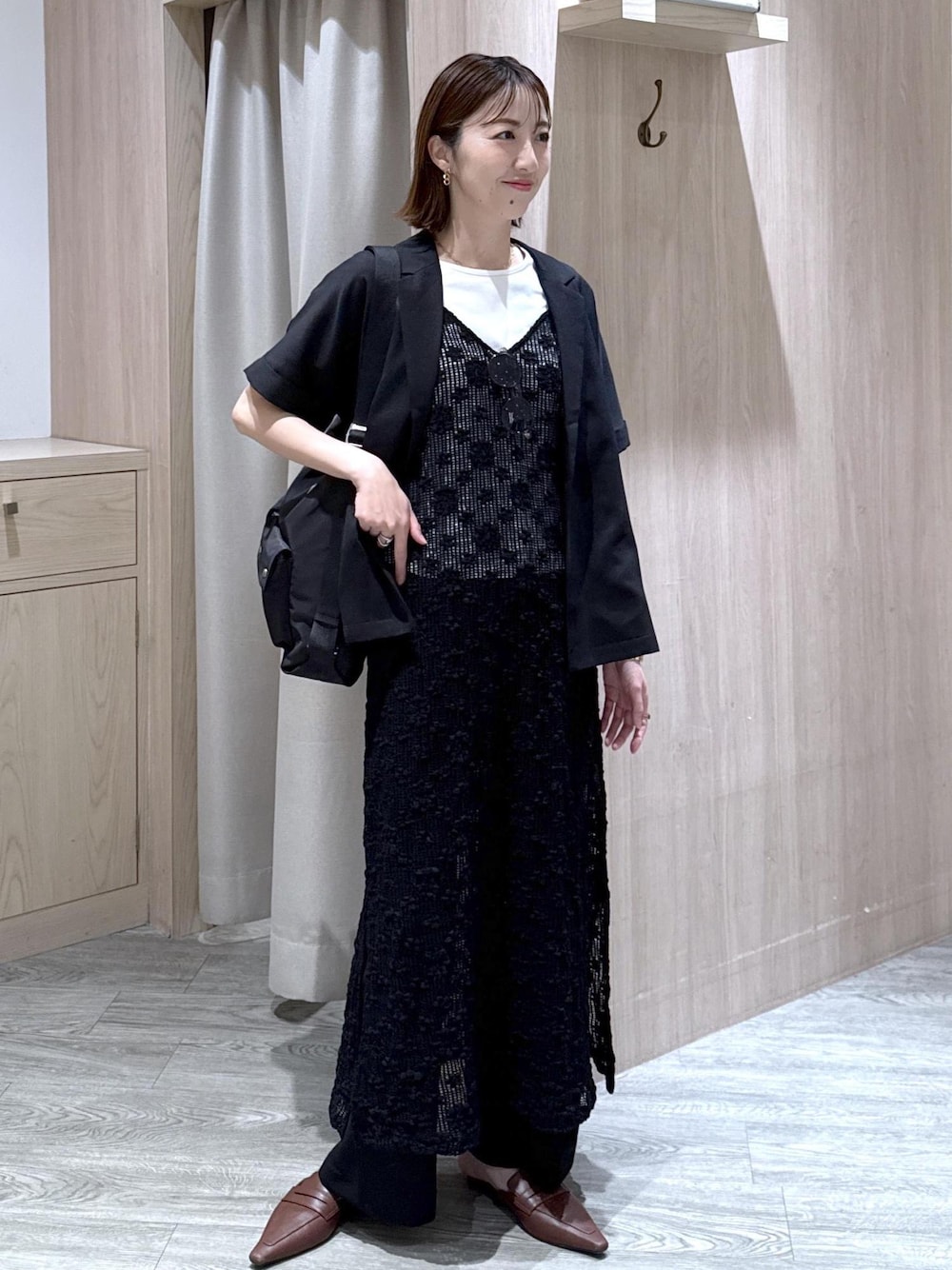 ブラック系のテーラードジャケット、ブラック系のショルダーバッグ、ホワイト系のTシャツ/カットソーを着用したレディースの春コーディネートの1枚目の写真