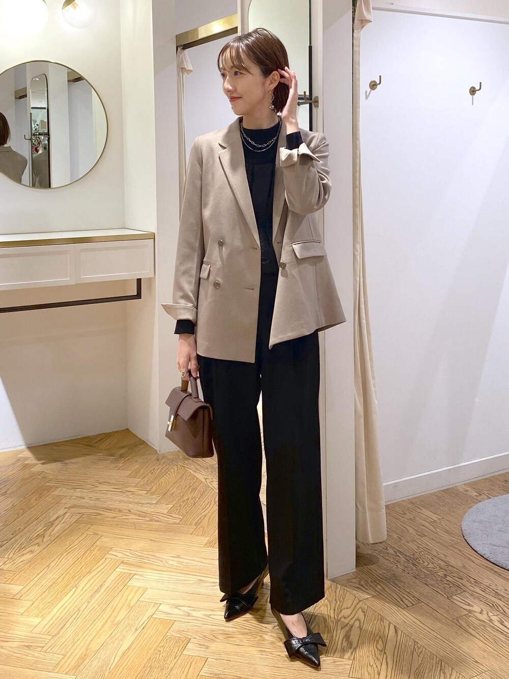 ブラック系のパンプス、ブラック系のニット/セーター、ブラック系のスラックスを着用したレディースの冬コーディネートの1枚目の写真