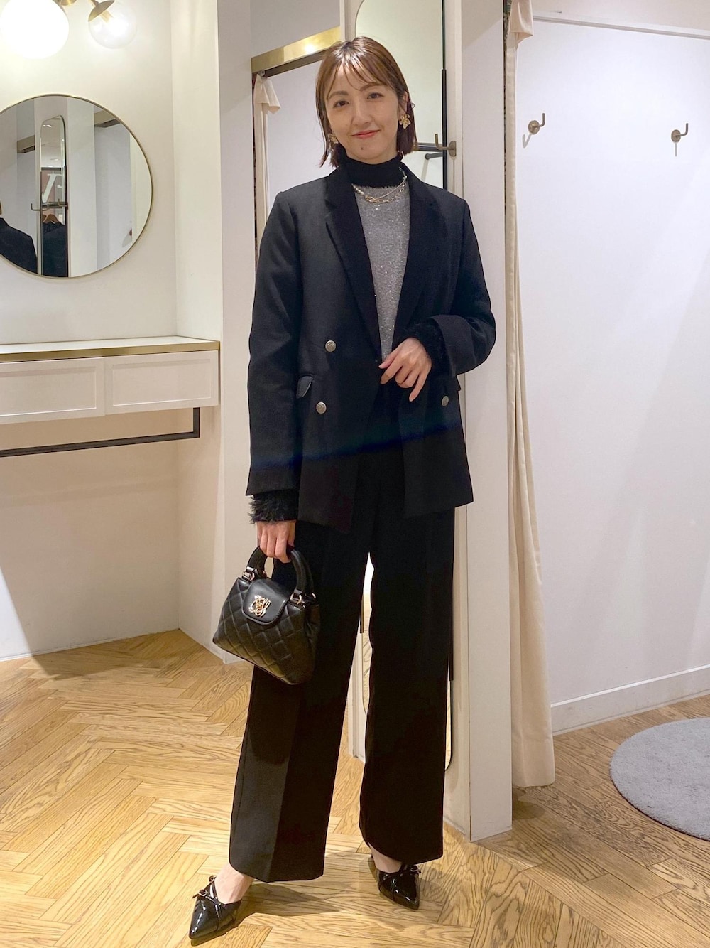 ブラック系のニット/セーター、ブラック系のスラックス、ブラック系のテーラードジャケットを着用したレディースの冬コーディネートの1枚目の写真