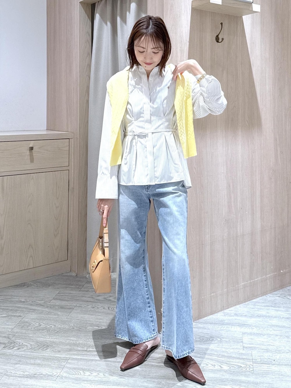 ブルー系のデニムパンツ、イエロー系のショルダーバッグ、ベージュ系のシャツ/ブラウスを着用したレディースの春コーディネートの1枚目の写真