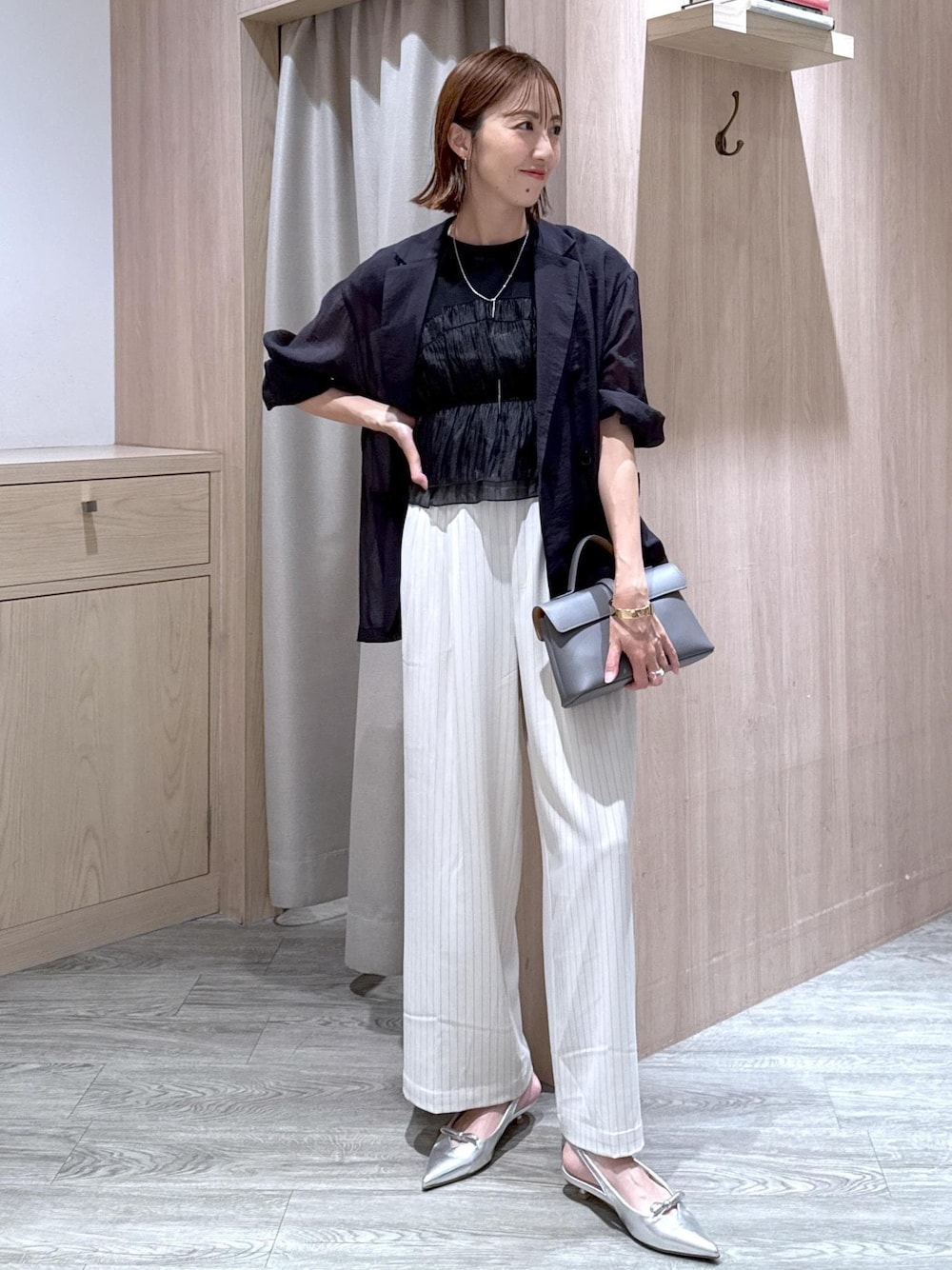 グレー系のショルダーバッグ、シルバー系のパンプス、ブラック系のTシャツ/カットソーを着用したレディースの夏コーディネートの1枚目の写真