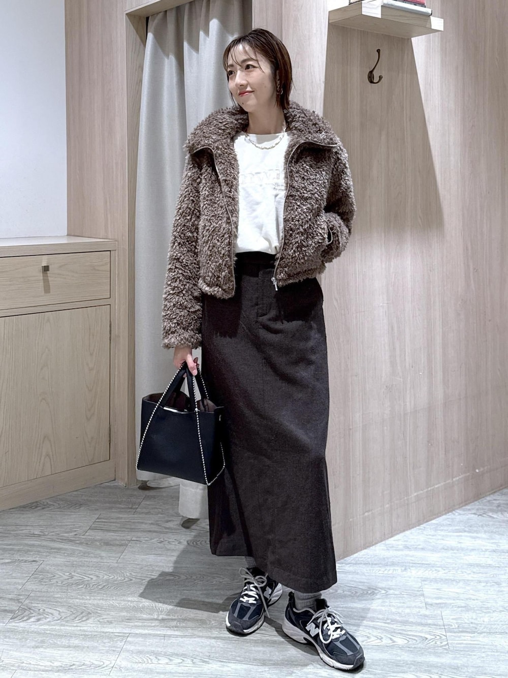 ブラウン系のスカート、ブラウン系のブルゾン、ホワイト系のスウェットを着用したレディースの秋コーディネートの1枚目の写真