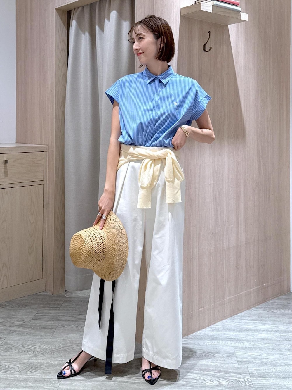 ブラック系のサンダル、ホワイト系のカーディガン/ボレロ、ブルー系のシャツ/ブラウスを着用したレディースの夏コーディネートの1枚目の写真