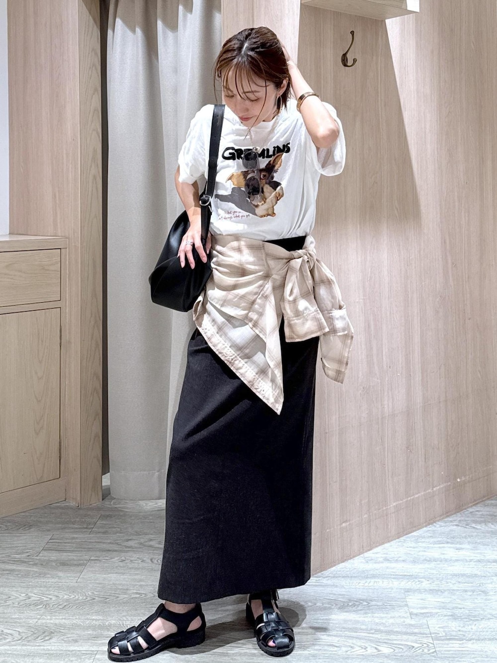 グレー系のスカート、ベージュ系のシャツ/ブラウス、ホワイト系のTシャツ/カットソーを着用したレディースの夏コーディネートの1枚目の写真