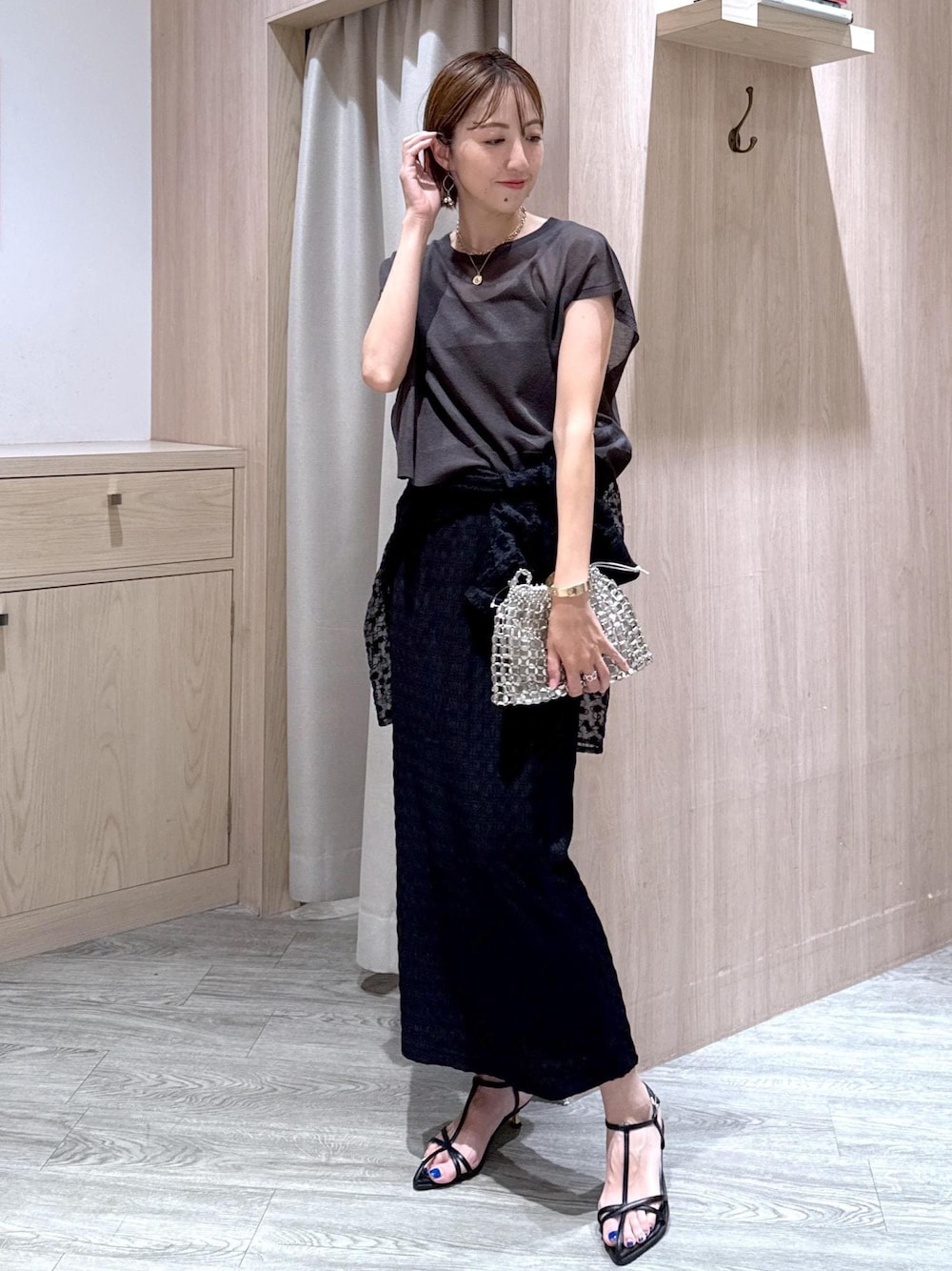 ブラック系のサンダル、シルバー系のハンドバッグ、ブラック系のシャツ/ブラウスを着用したレディースの夏コーディネートの1枚目の写真