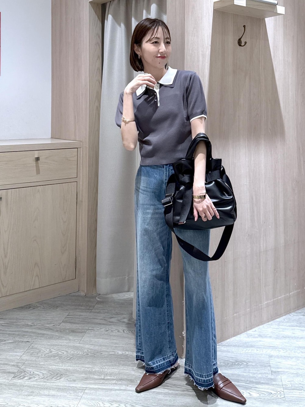 ホワイト系のキャミソール、ブラック系のトートバッグ、ブルー系のデニムパンツを着用したレディースの春コーディネートの1枚目の写真
