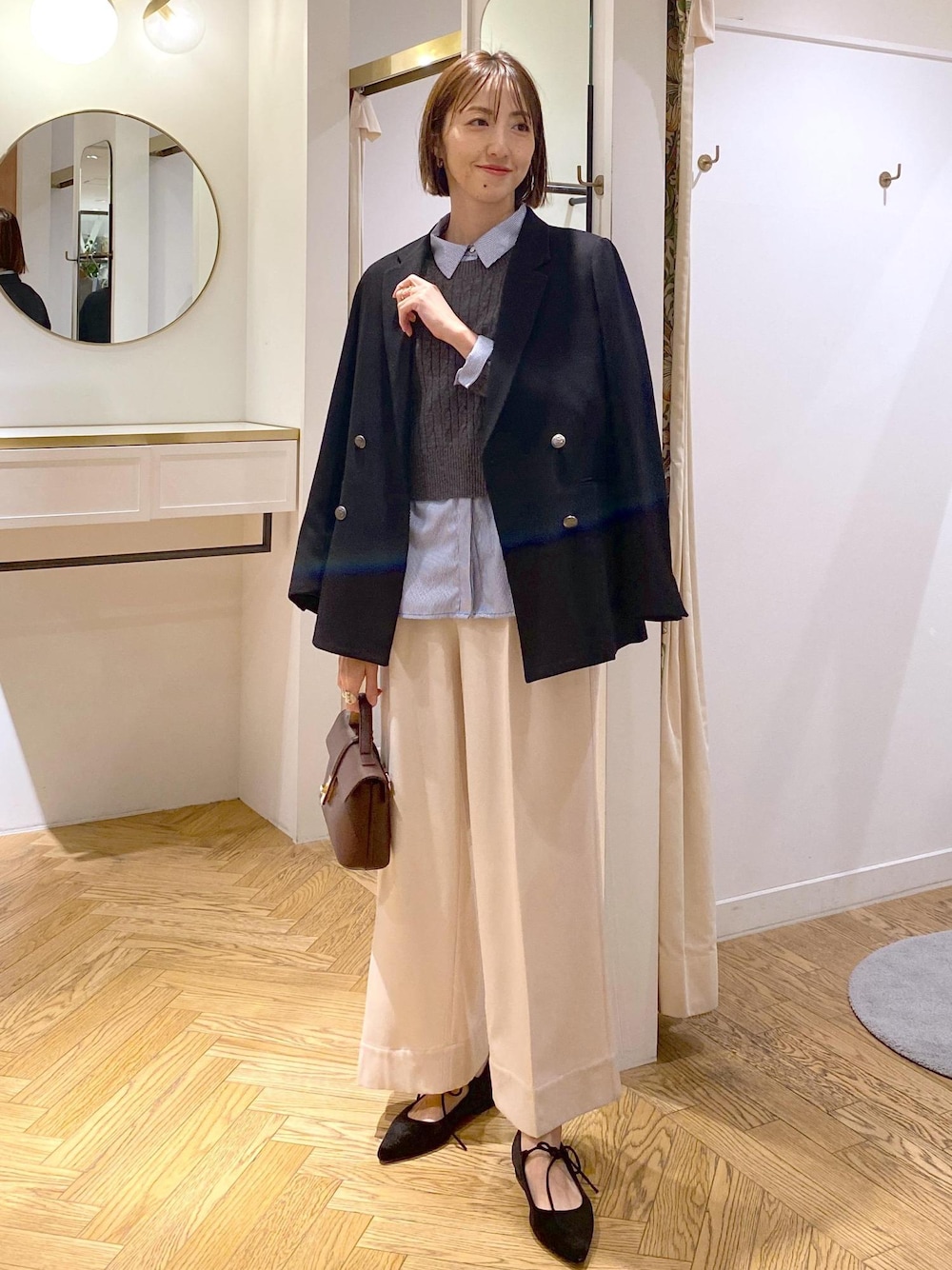 ブラウン系のショルダーバッグ、ブラック系のテーラードジャケット、ブルー系のシャツ/ブラウスを着用したレディースの冬コーディネートの1枚目の写真