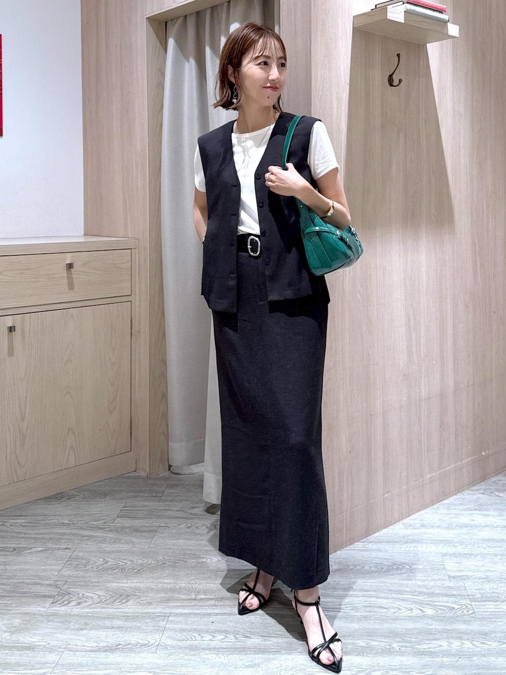 ブラック系のサンダル、グレー系のスカート、ホワイト系のTシャツ/カットソーを着用したレディースの夏コーディネートの1枚目の写真