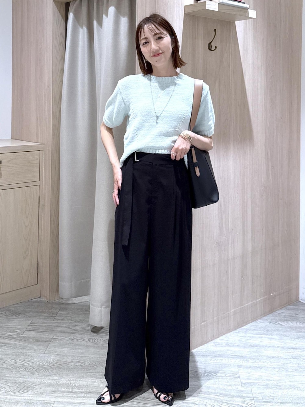 ブラック系のトートバッグ、ブラック系のその他パンツ、グリーン系のニット/セーターを着用したレディースの夏コーディネートの1枚目の写真