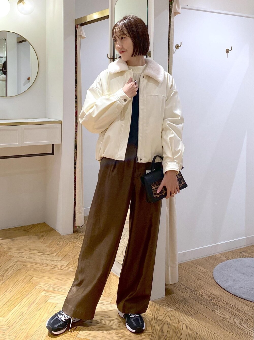 ホワイト系のブルゾン、ホワイト系のニット/セーター、ブラウン系のその他パンツを着用したレディースの冬コーディネートの1枚目の写真