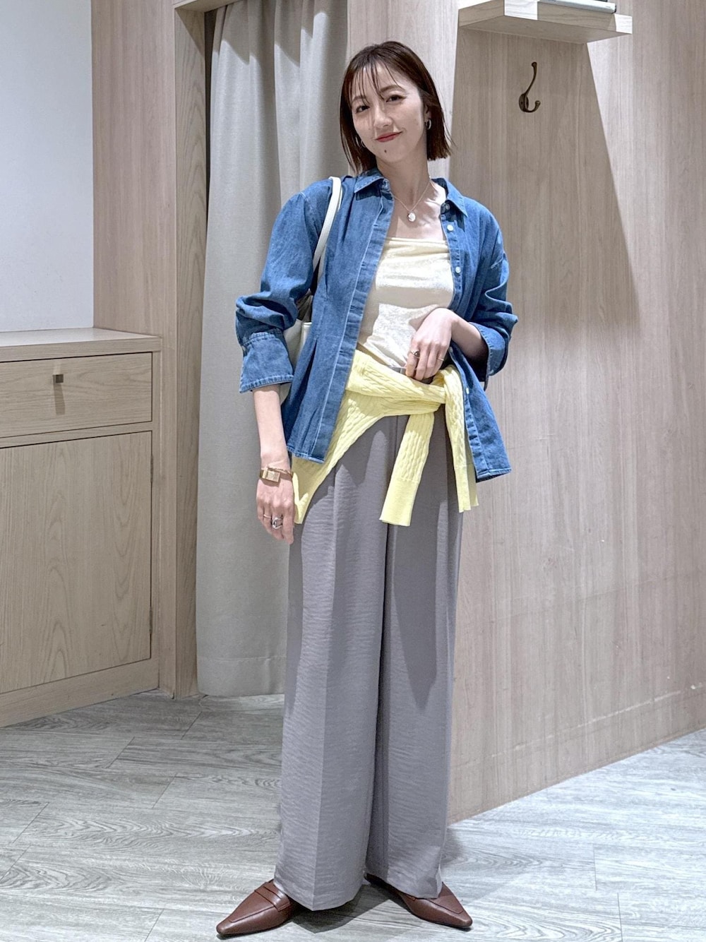 グレー系のその他パンツ、イエロー系のカーディガン/ボレロ、ブルー系のシャツ/ブラウスを着用したレディースの春コーディネートの1枚目の写真
