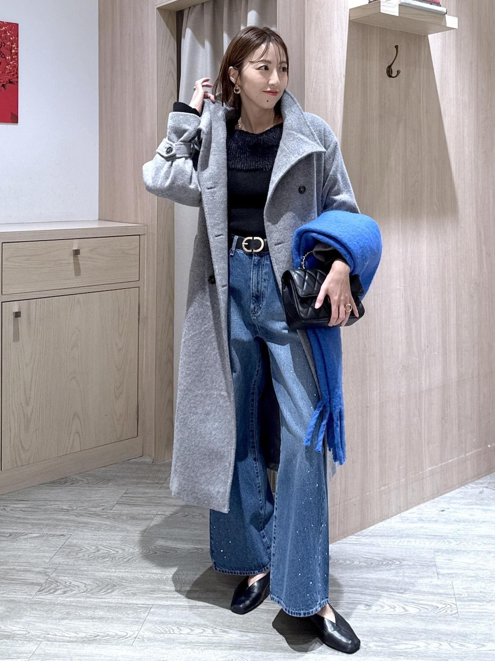 グレー系のその他アウター、ブルー系のデニムパンツ、ブラック系のニット/セーターを着用したレディースの冬コーディネートの1枚目の写真