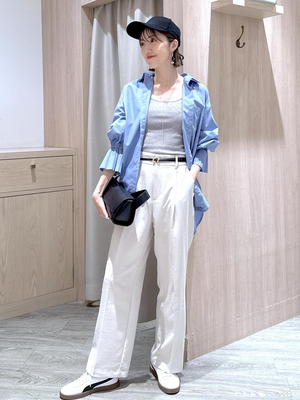 グレー系のタンクトップ、ブルー系のシャツ/ブラウス、ブラック系のショルダーバッグを着用したレディースの春コーディネートの1枚目の写真