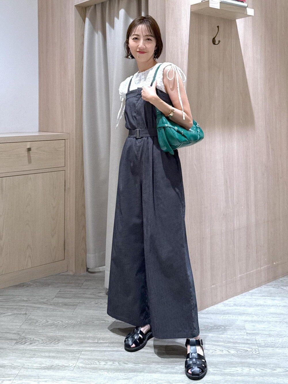 ホワイト系のキャミソール、ホワイト系のシャツ/ブラウス、グリーン系のハンドバッグを着用したレディースの夏コーディネートの1枚目の写真