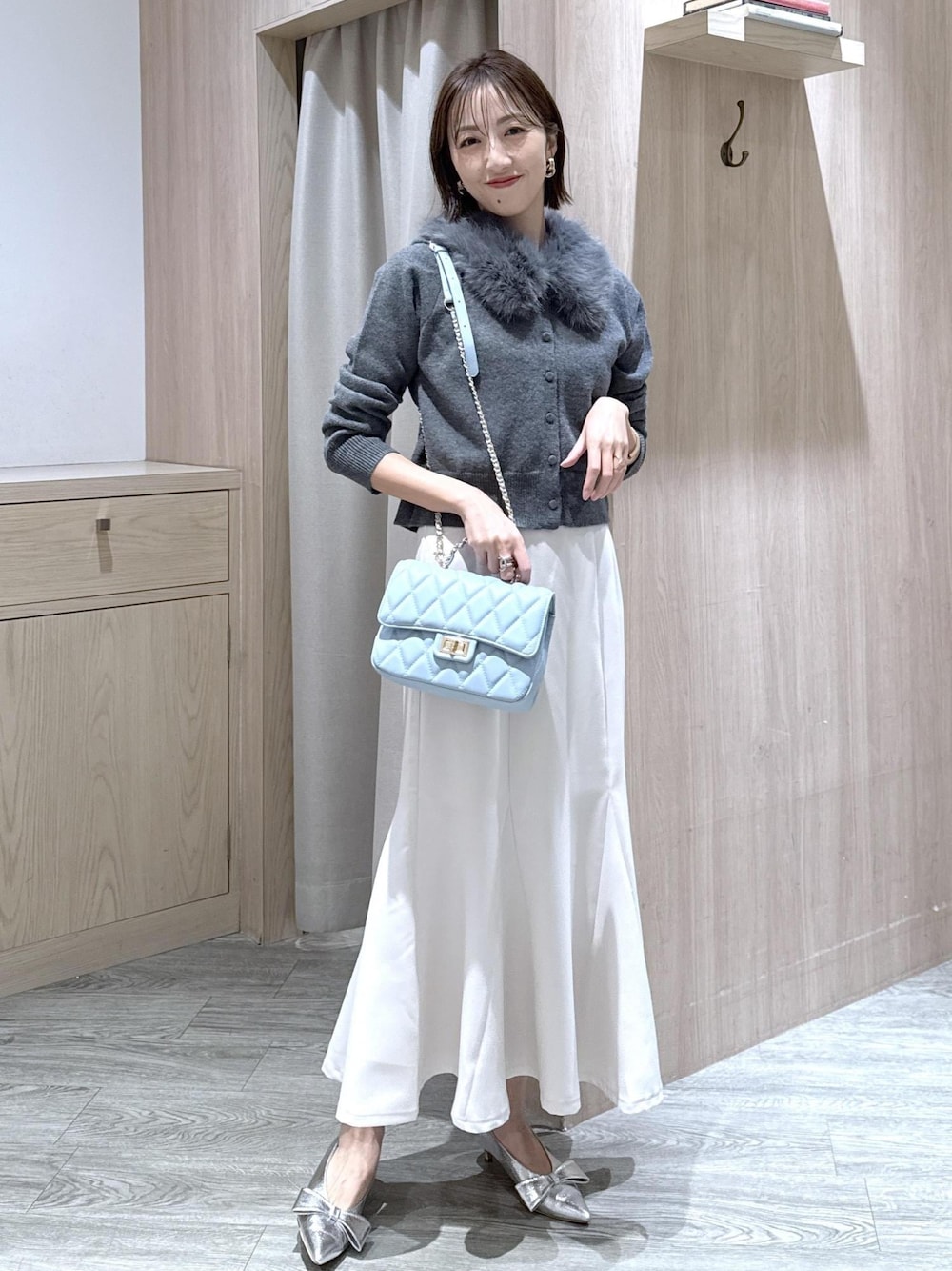 シルバー系のパンプス、ホワイト系のキャミソール、ホワイト系のスカートを着用したレディースの冬コーディネートの1枚目の写真