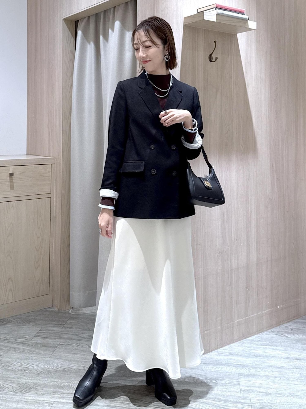 ブラック系のショルダーバッグ、ブラック系のテーラードジャケット、ブラック系のブーツを着用したレディースの冬コーディネートの1枚目の写真