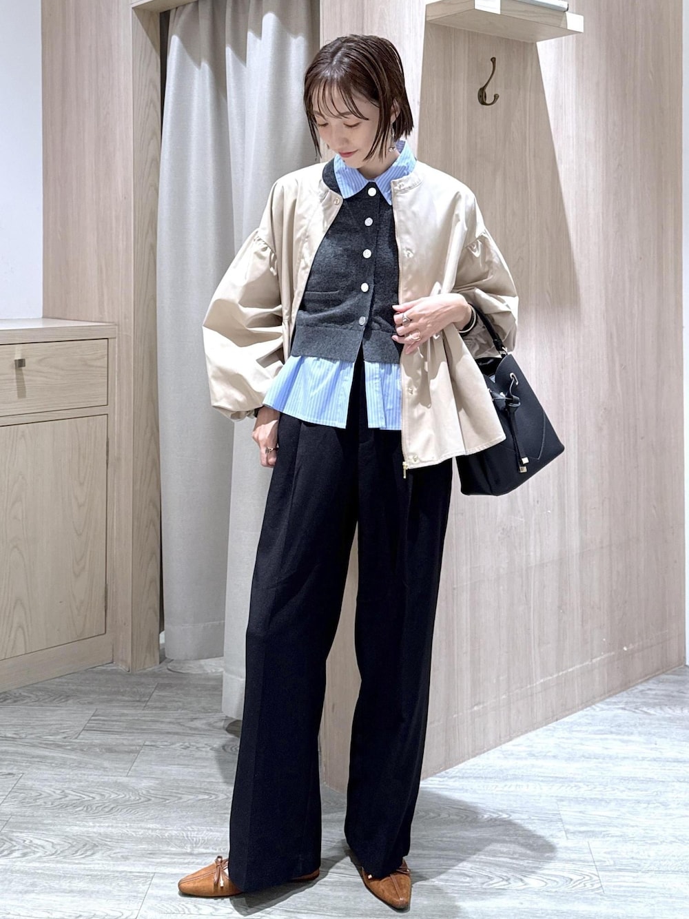 ブラック系のショルダーバッグ、イエロー系のパンプス、ベージュ系のブルゾンを着用したレディースの秋コーディネートの1枚目の写真