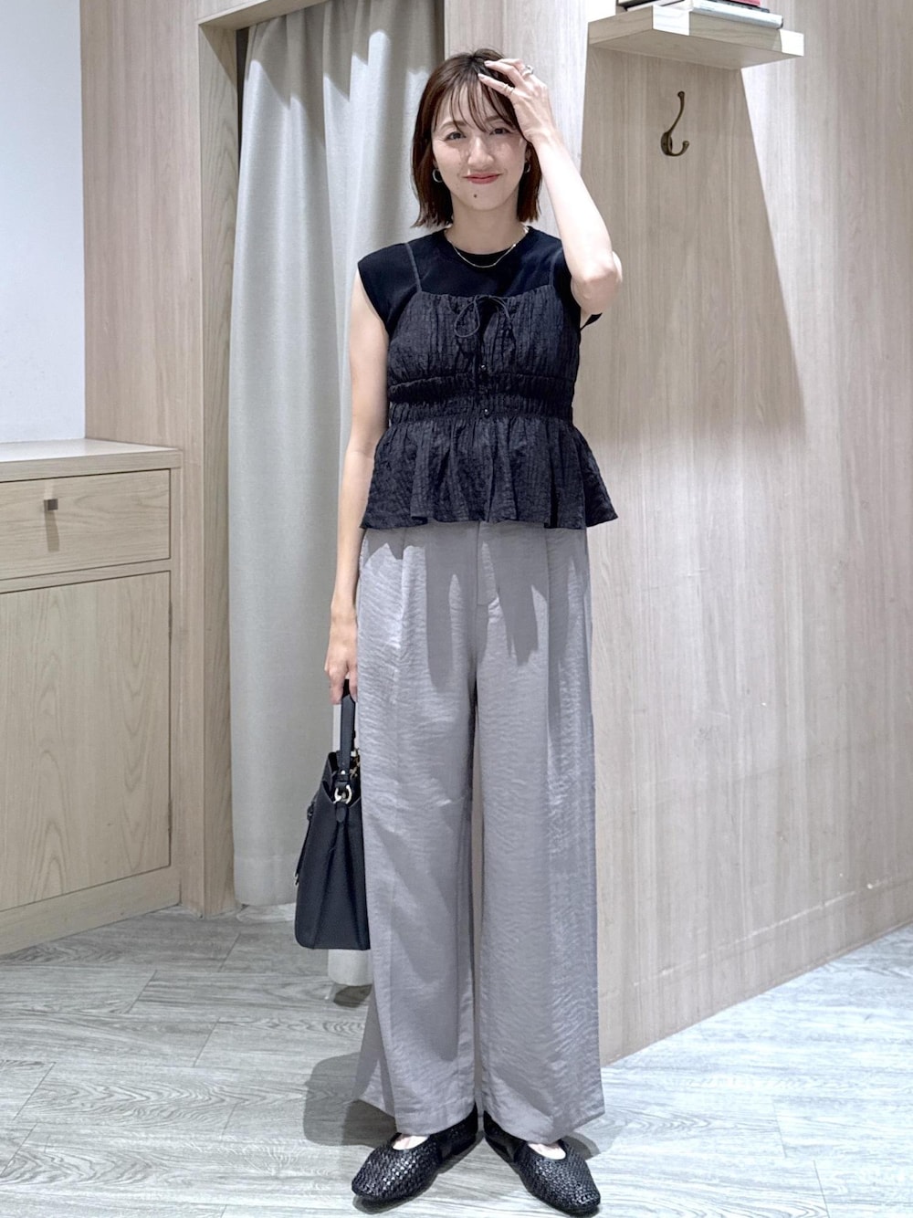 ブラック系のショルダーバッグ、グレー系のその他パンツ、ブラック系のパンプスを着用したレディースの夏コーディネートの1枚目の写真