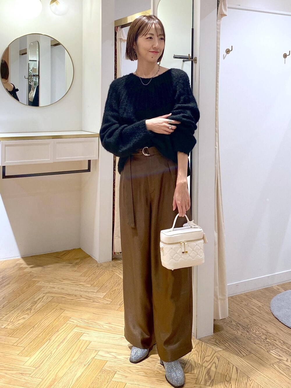 シルバー系のブーツ、ブラック系のニット/セーター、ブラウン系のその他パンツを着用したレディースの冬コーディネートの1枚目の写真