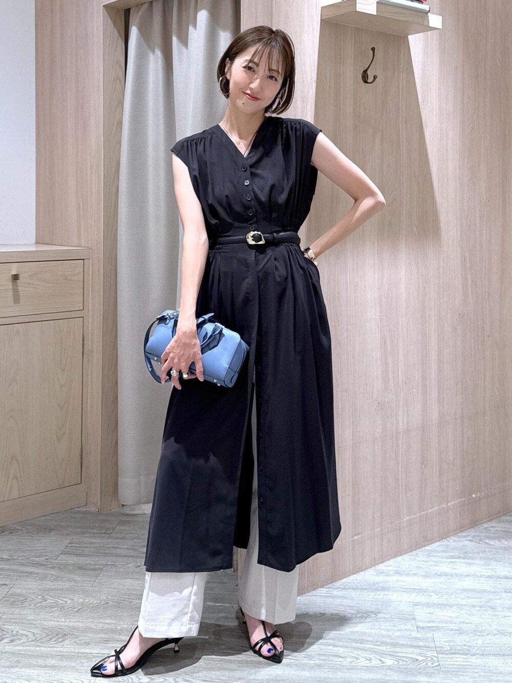 ブラック系のサンダル、ホワイト系のスラックス、ブラック系のワンピースを着用したレディースの夏コーディネートの1枚目の写真