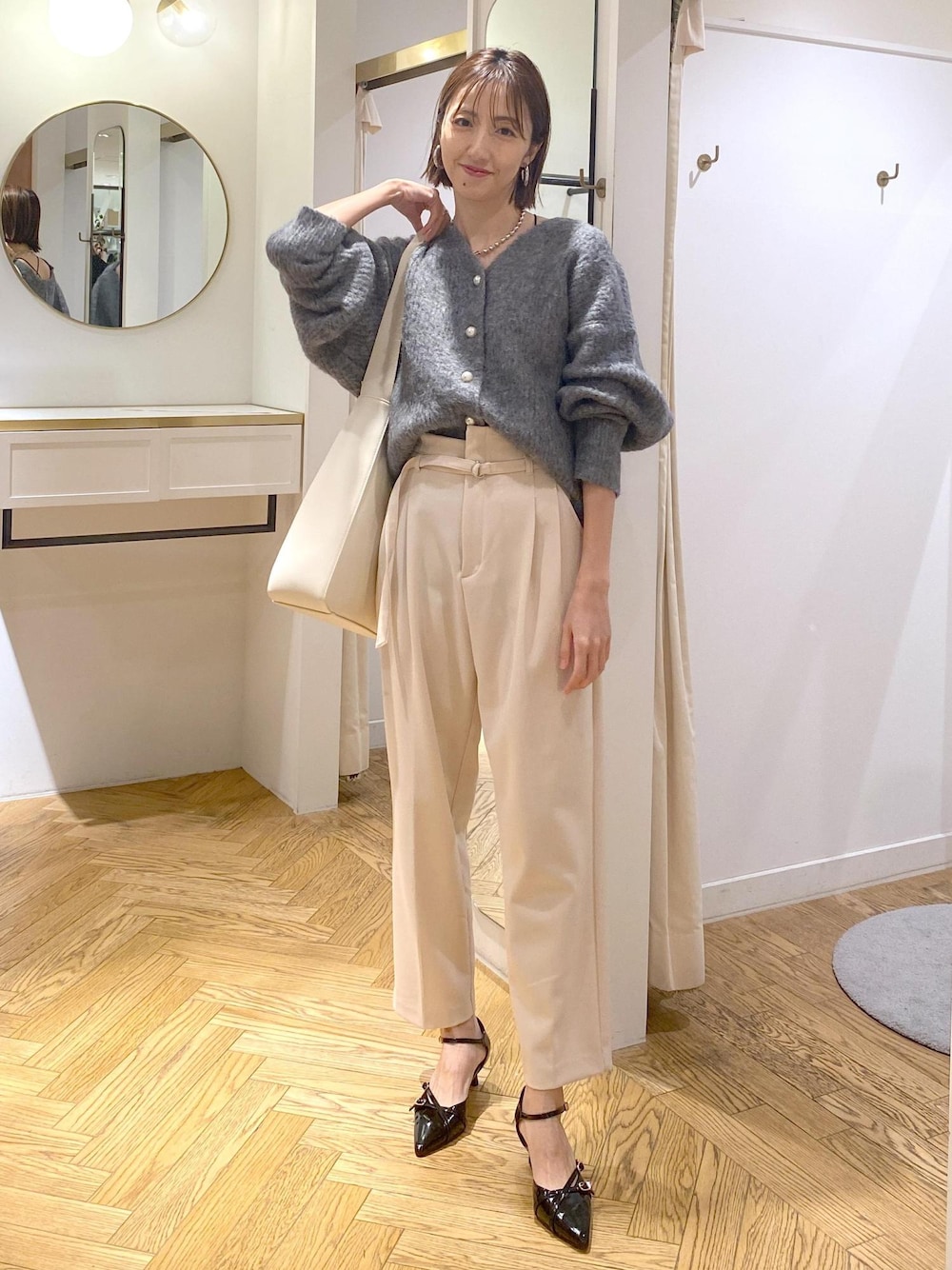 ホワイト系のトートバッグ、ブラック系のパンプス、ベージュ系のその他パンツを着用したレディースの冬コーディネートの1枚目の写真