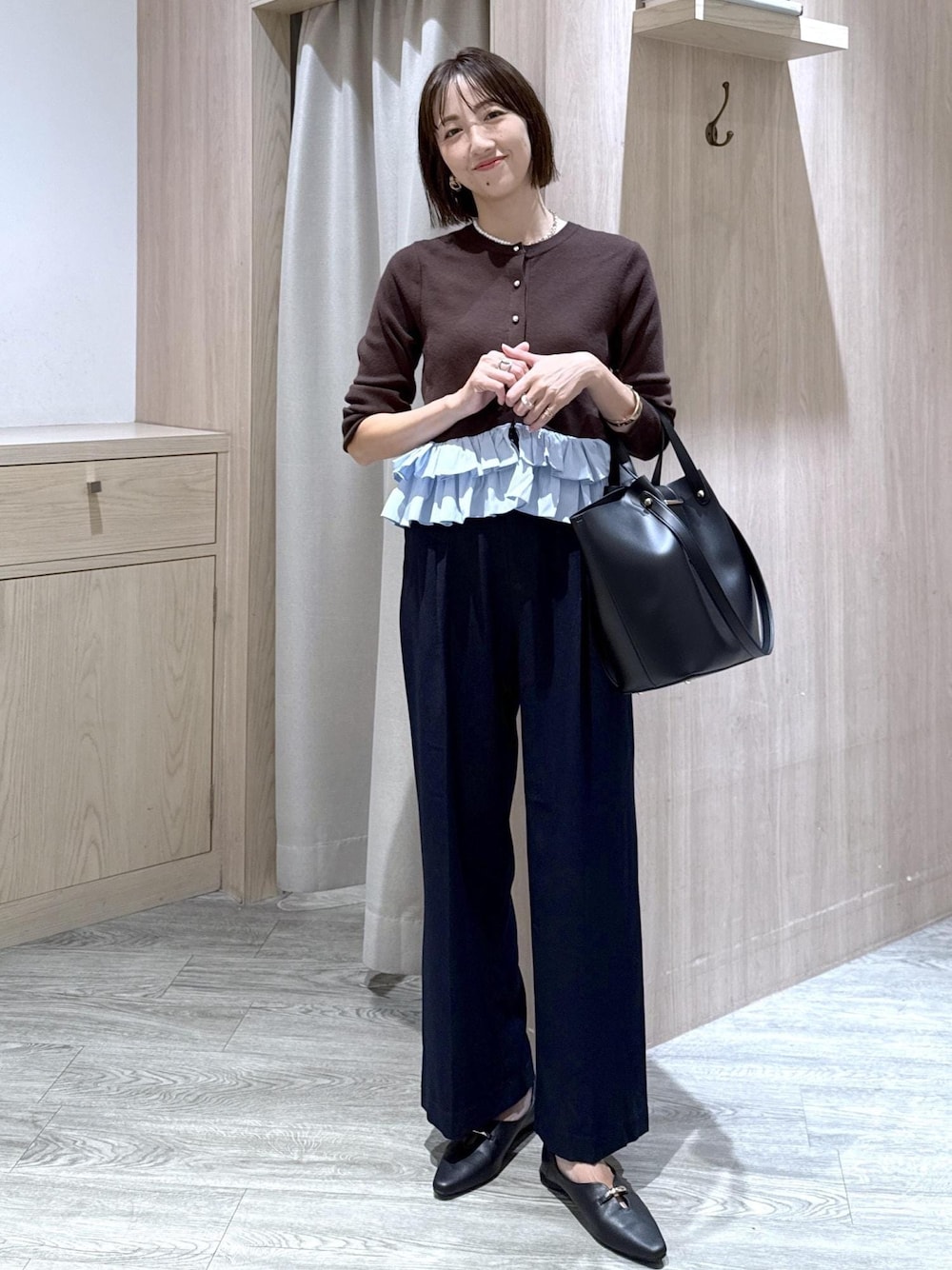 ブラック系のパンプス、ブルー系のその他パンツ、ブラック系のビジネスバッグを着用したレディースの秋コーディネートの1枚目の写真