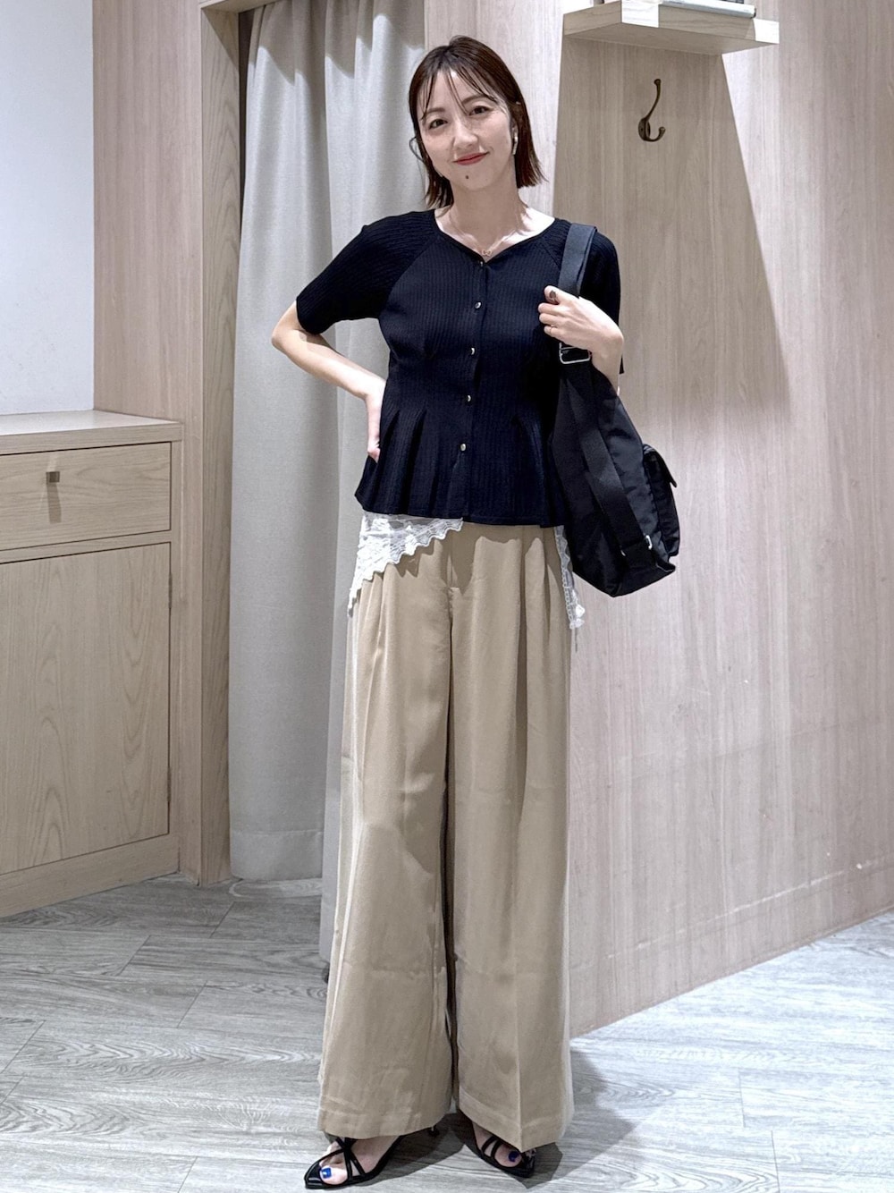 ベージュ系のその他パンツ、ブラック系のカーディガン/ボレロ、ブラック系のショルダーバッグを着用したレディースの春コーディネートの1枚目の写真
