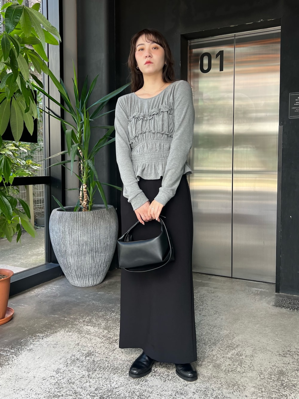 グレー系のTシャツ/カットソー、ブラック系のショルダーバッグ、ブラック系のスカートを着用したレディースの秋コーディネートの1枚目の写真