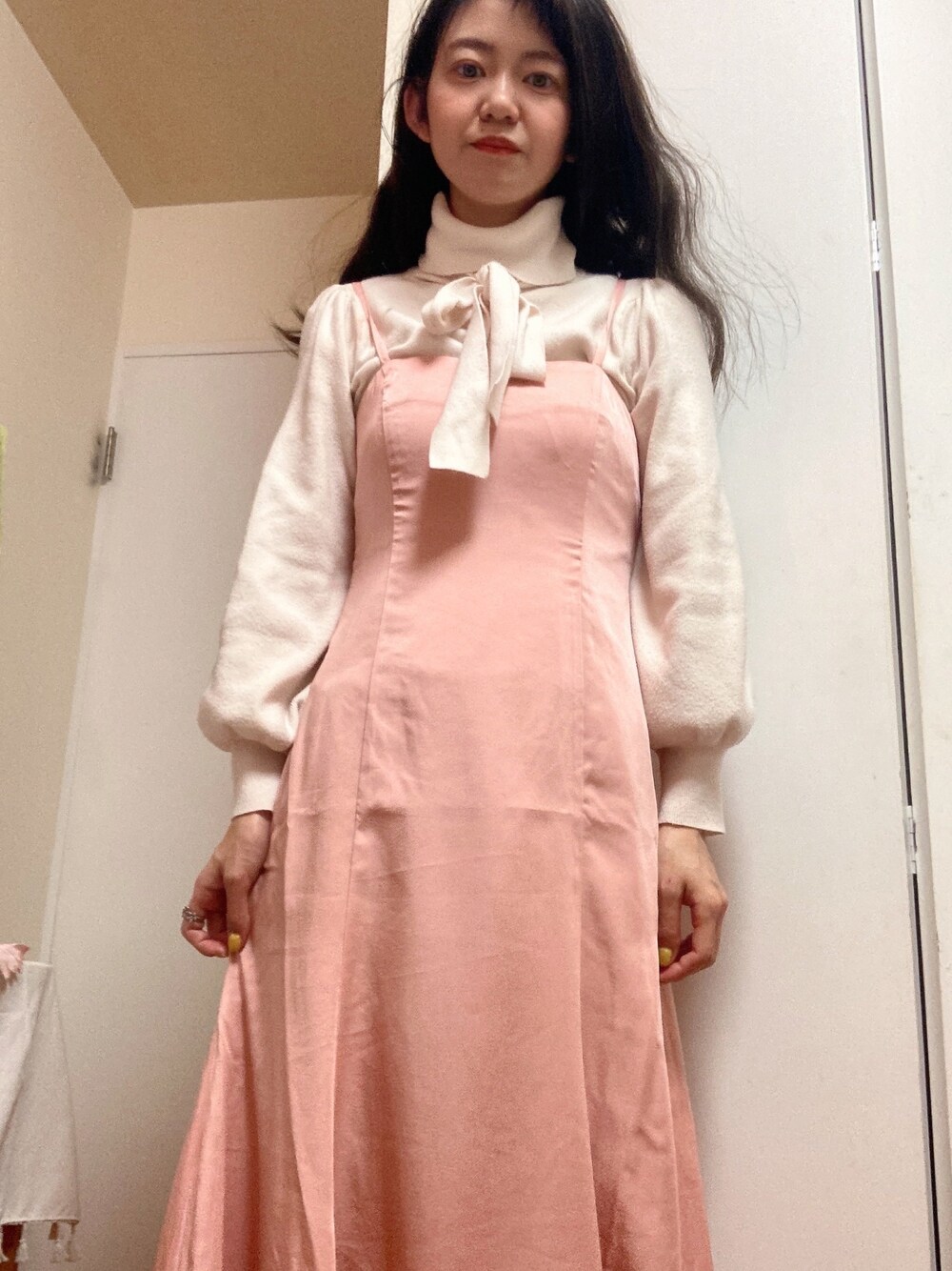 ピンク系のワンピースを着用したレディースの冬コーディネートの1枚目の写真