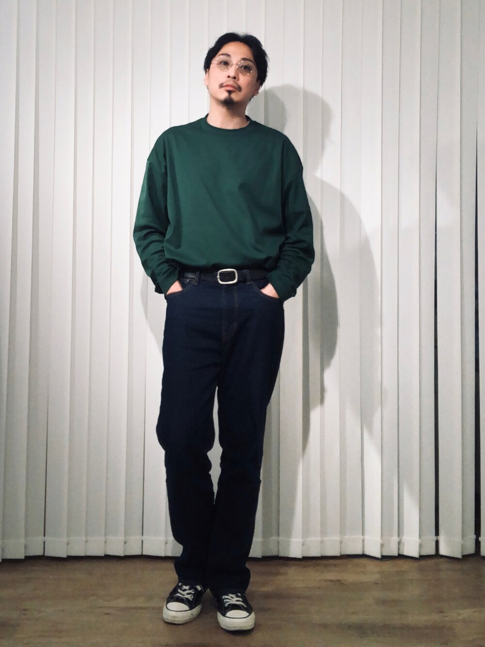 グリーン系のTシャツ/カットソー、ブルー系のスラックス、ブラック系のスニーカーを着用したメンズの春コーディネートの1枚目の写真